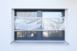 Ein Fenster ist zu einen Drittel mit Malerfolie abgeklebt